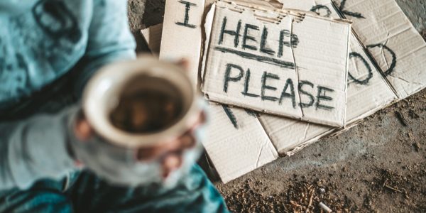 Beggars sitting under a bridge with cups have money.